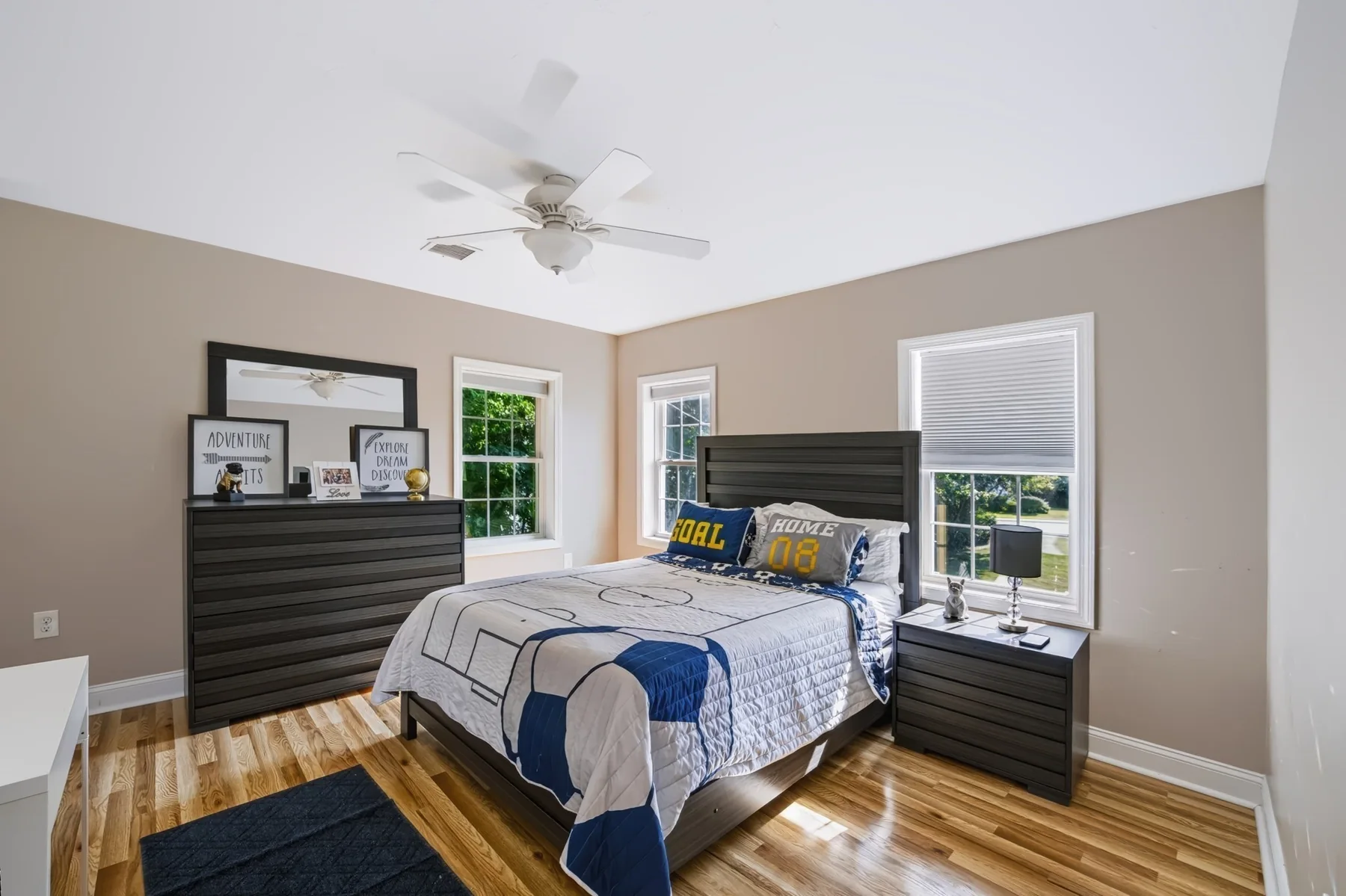Bedroom with windows and dark wood furniture