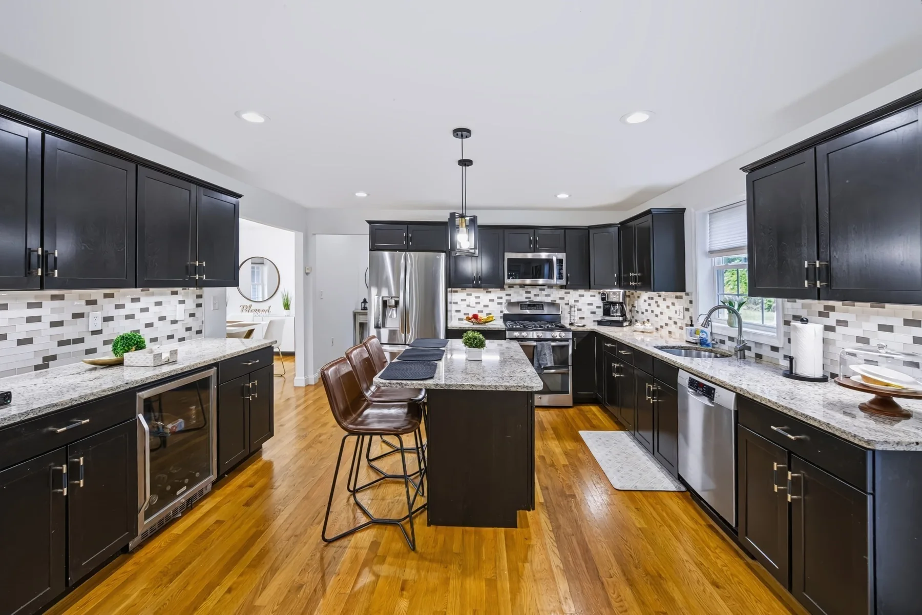 Kitchen with dark cabinets, granite island and hardwood floor
